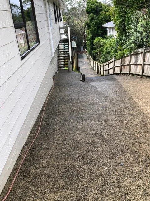 Concrete path beside a timber fence after washing