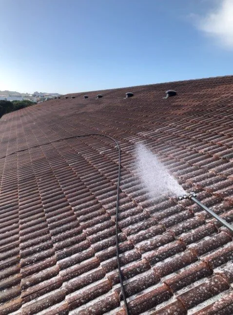 Terracotta tile roof being treated with a low-pressure spray